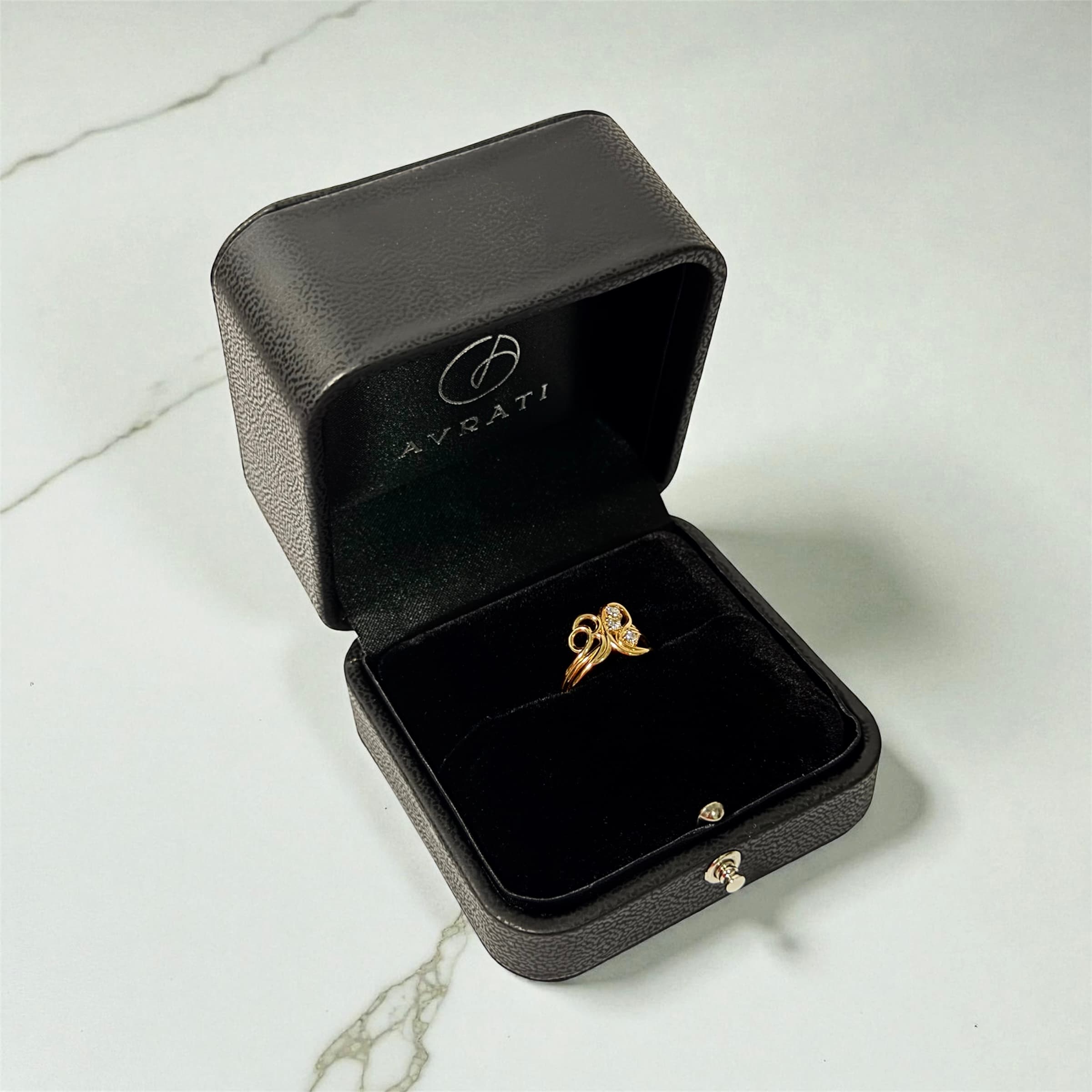 Gold ring in Avrati box on marble